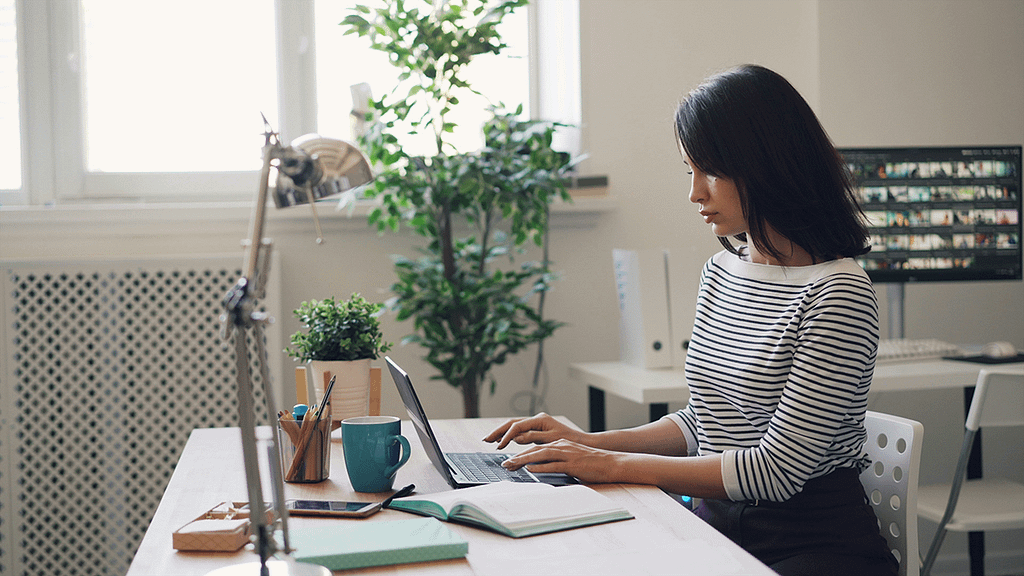 woman sitting at a desk typing on computer